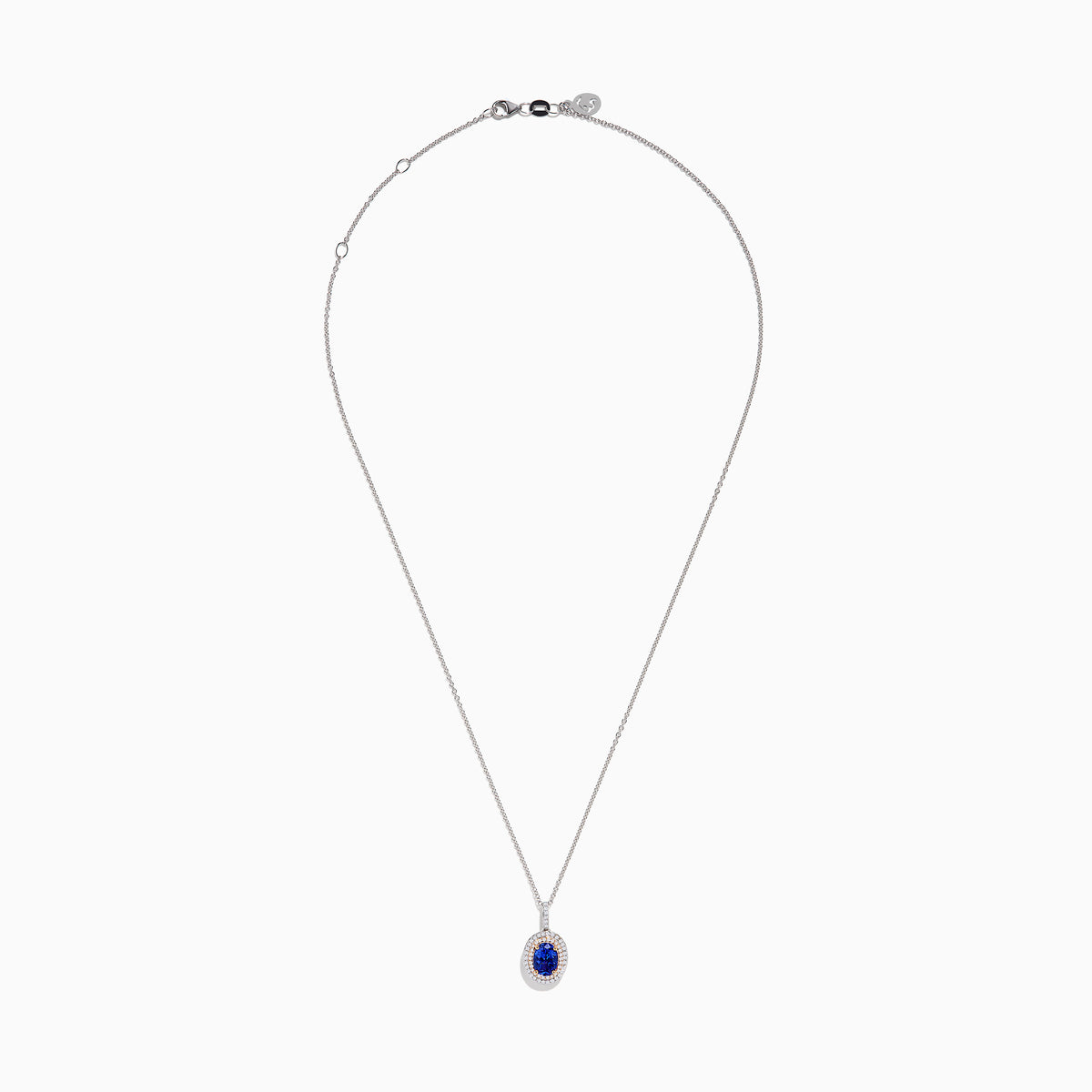 The Nahla Siri 14K White & Rose Gold Tanzanite and Diamond Pendant features an oval tanzanite surrounded by a double halo of diamonds, all set on a delicate silver chain and photographed against a white background.