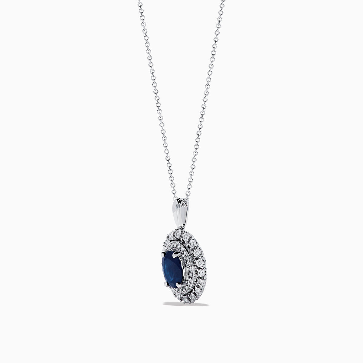 The Royal Bleu 14K White Gold Sapphire & Diamond Halo Pendant features a vibrant sapphire framed by two rows of sparkling white diamonds, all set in a chain necklace against a plain white background.
