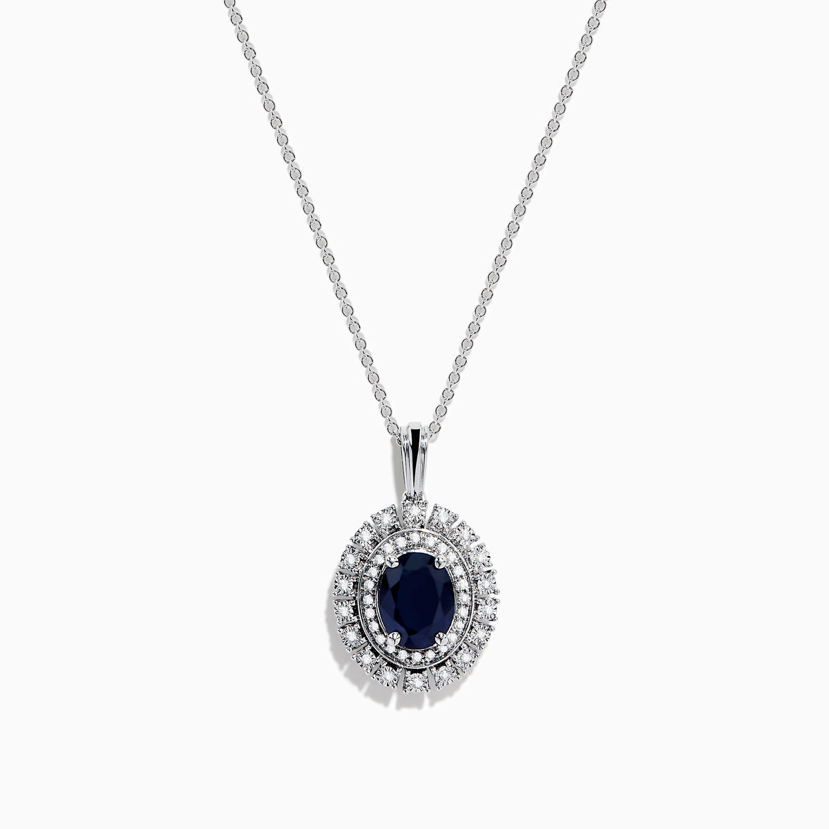 The Royal Bleu 14K White Gold Sapphire & Diamond Halo Pendant features a vibrant sapphire framed by two rows of sparkling white diamonds, all set in a chain necklace against a plain white background.