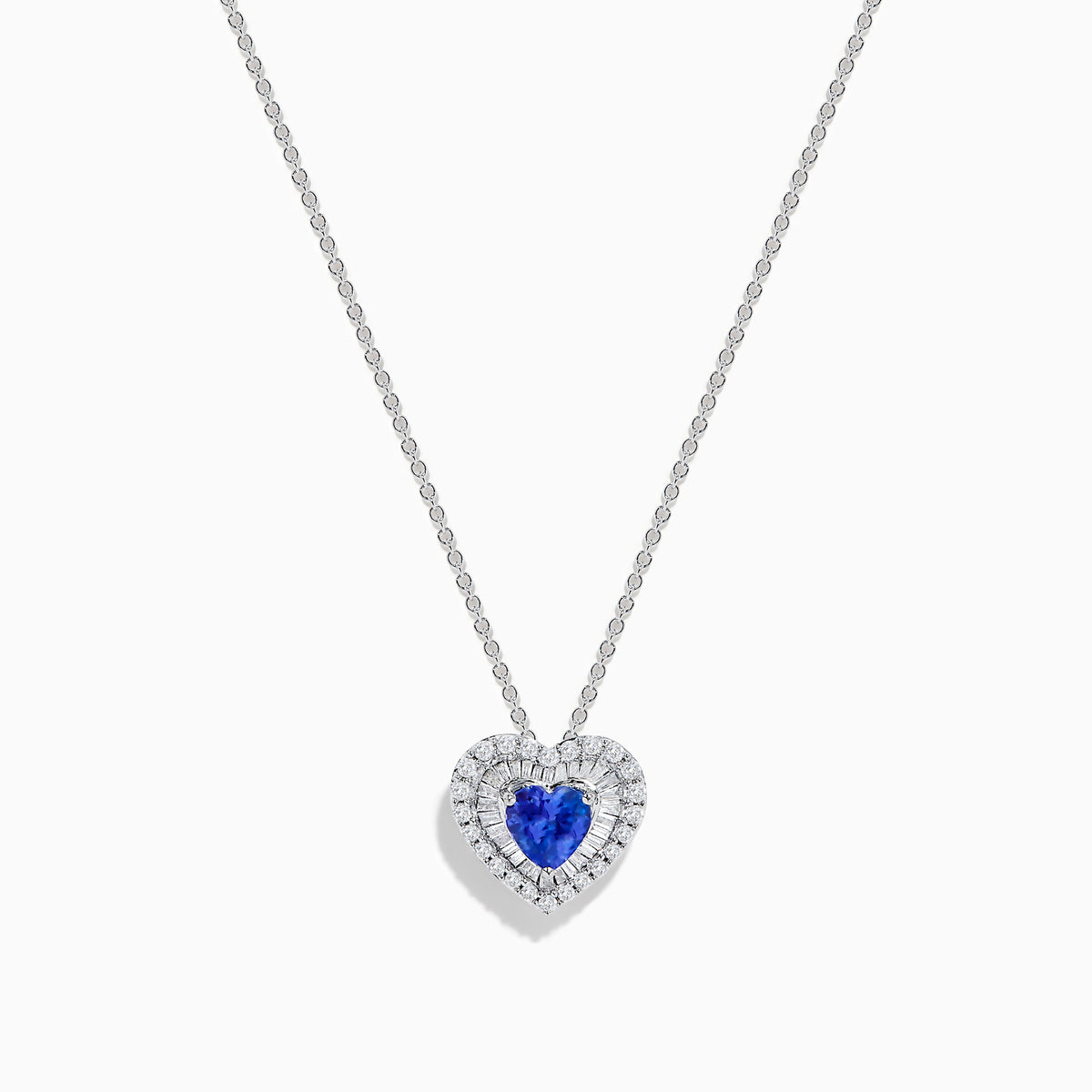 The Nahla Siri 14K White Gold Tanzanite and Diamond Heart Pendant showcases a vivid tanzanite at its center, encircled by sparkling diamonds, all set in white gold and displayed against a plain white background.