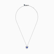 The Nahla Siri 14K White Gold Tanzanite and Diamond Heart Pendant showcases a vivid tanzanite at its center, encircled by sparkling diamonds, all set in white gold and displayed against a plain white background.
