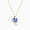 The Nahla Siri 14K Yellow Gold Tanzanite and Diamond Palm Tree Pendant features marquise-cut blue tanzanite leaves and sparkling diamonds accenting the curved trunk for added brilliance.