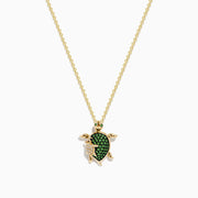 The Seaside 14K Yellow Gold Tsavorite and Diamond Turtle Pendant showcases a large turtle with a tsavorite shell and a smaller diamond-encrusted turtle, both suspended from a delicate gold chain.