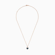 The Bella Bleu 14K Rose Gold Blue and White Diamond Heart Pendant features a heart-shaped design with blue diamonds at the center, bordered by white diamonds, hanging vertically on a rose gold chain against a white background.