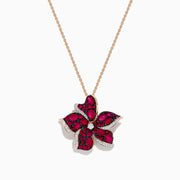 The Ruby Royale 14K Rose Gold Ruby and Diamond Flower Pendant showcases a rose gold chain with a flower-shaped design, featuring vibrant rubies, black stones, and sparkling diamonds at the center and petal edges.