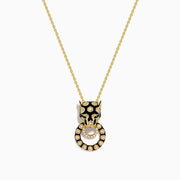 The Signature 14K Yellow Gold Diamond and Enamel Panther Pendant features a sparkling diamond-adorned circular ring gripped by a black and gold panther head, hanging from an elegant chain.