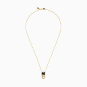 The Signature 14K Yellow Gold Diamond and Emerald Panther Pendant features a panther’s head with green gemstone eyes, black enamel detail, and a diamond-studded ring held in its mouth.