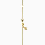 The Signature 14K Yellow Gold Diamond and Emerald Panther Pendant features a panther’s head with green gemstone eyes, black enamel detail, and a diamond-studded ring held in its mouth.
