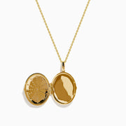 The 14K Yellow Gold Diamond Locket Pendant features an oval sunburst design with sparkling diamonds set on black enamel.