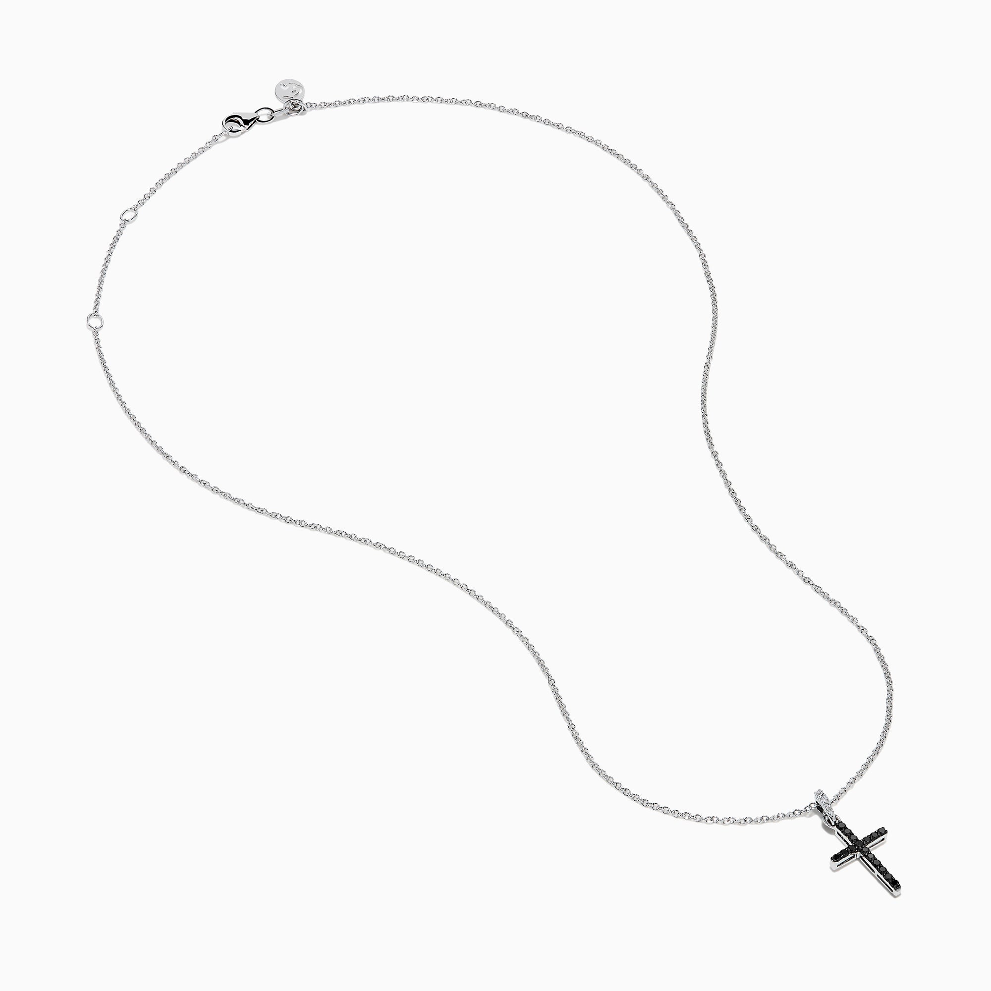 The Novelty 14K White Gold Black and White Diamond Cross Pendant features black stones and a single clear stone at the top, shown on a silver chain against a plain white background.