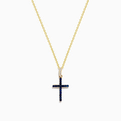The Novelty 14K Yellow Gold Sapphire and Diamond Cross Pendant features a cross adorned with sapphires and sparkling diamonds, shown on a plain white background.