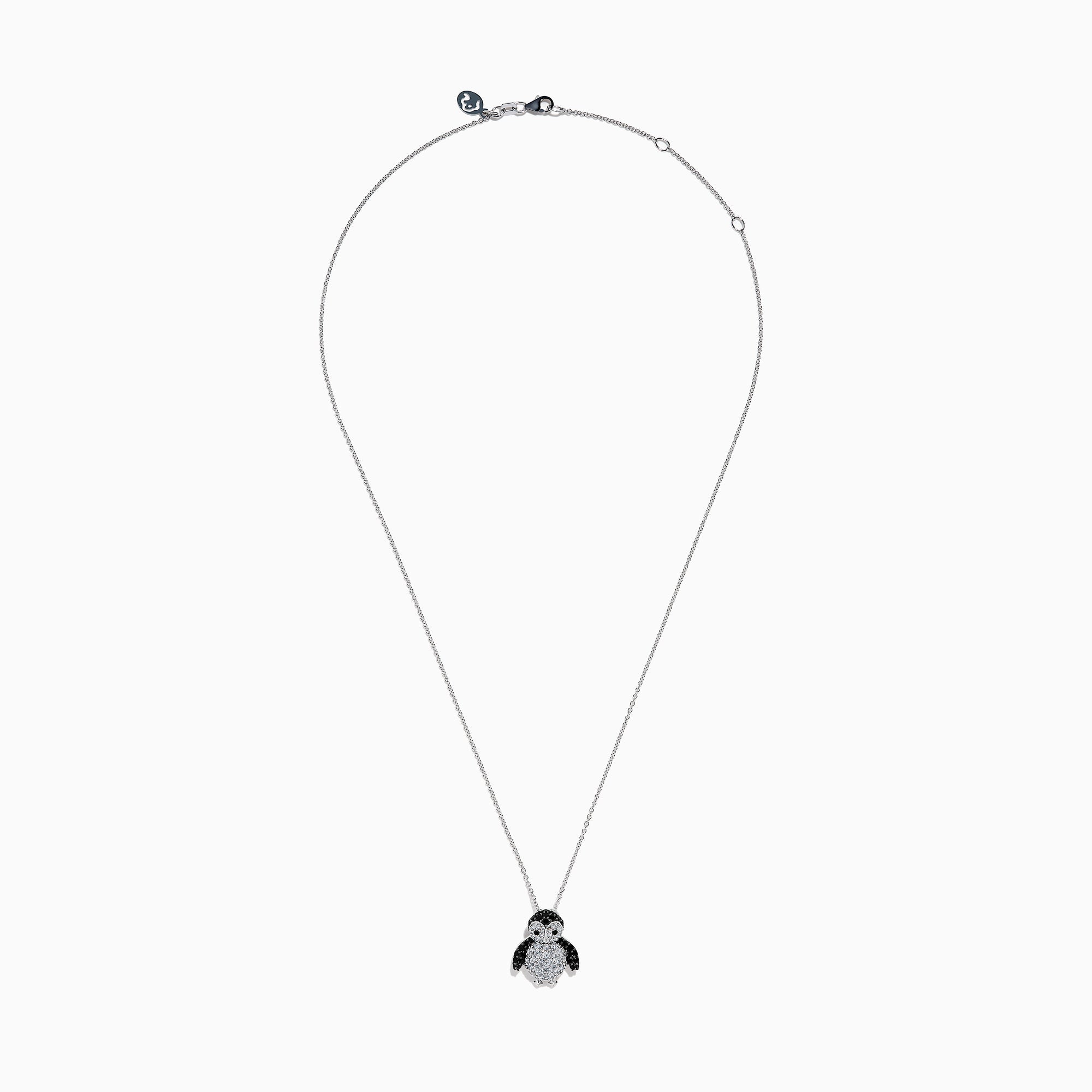 A 14K white gold necklace featuring a penguin pendant accented with diamonds, white sapphires, and black spinel.