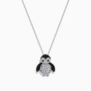A 14K white gold necklace featuring a penguin pendant accented with diamonds, white sapphires, and black spinel.
