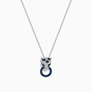The Signature 14K White Gold Blue Sapphire and Diamond Panther Pendant showcases a diamond-studded panther head with blue and white gemstones, gripping a vivid blue sapphire pendant ring in its mouth.