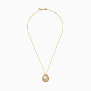 The 14K Yellow Gold Diamond Interlocking Double Circle Pendant features two connected circles—one smooth with diamonds, the other textured—suspended from a delicate gold chain for an elegant look.