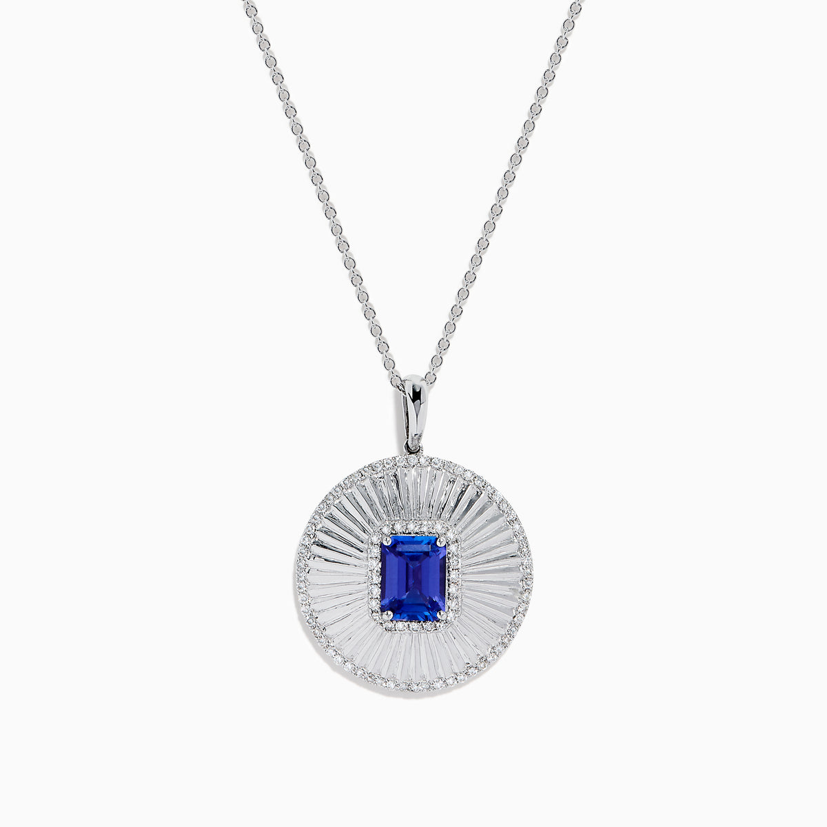 The 14K White Gold Tanzanite and Diamond Fluted Circle Pendant features a round diamond-accented design with a radiant motif and a central emerald-cut blue tanzanite stone.