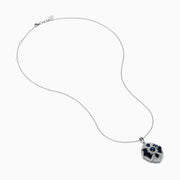 The 14K White Gold Sapphire and Diamond Vintage Pendant features deep blue sapphires and sparkling diamonds in a geometric design, suspended from a delicate white gold chain, all displayed on a white background.
