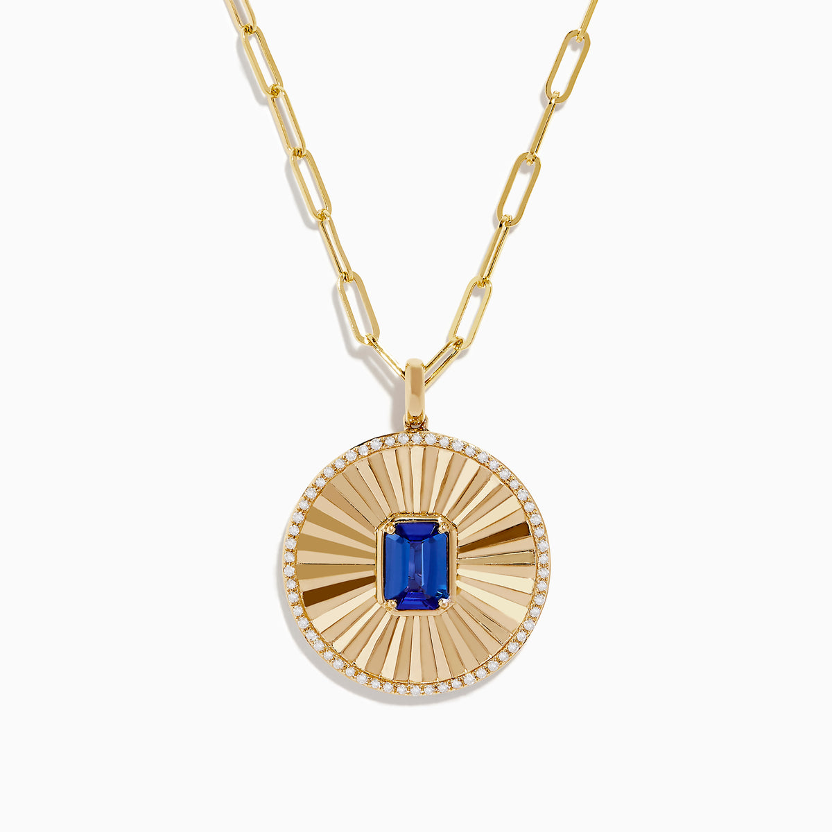 The Nahla Siri 14K Yellow Gold Tanzanite and Diamond Pendant features a round sunburst design with a central blue tanzanite gemstone, accented by diamonds, on an elongated link gold chain.
