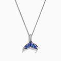 The 925 Silver Tanzanite and Diamond Whale Tail Pendant features a whale tail design with blue tanzanite gemstones and sparkling diamonds, crafted in 925 silver for a stunning shine against a white background.