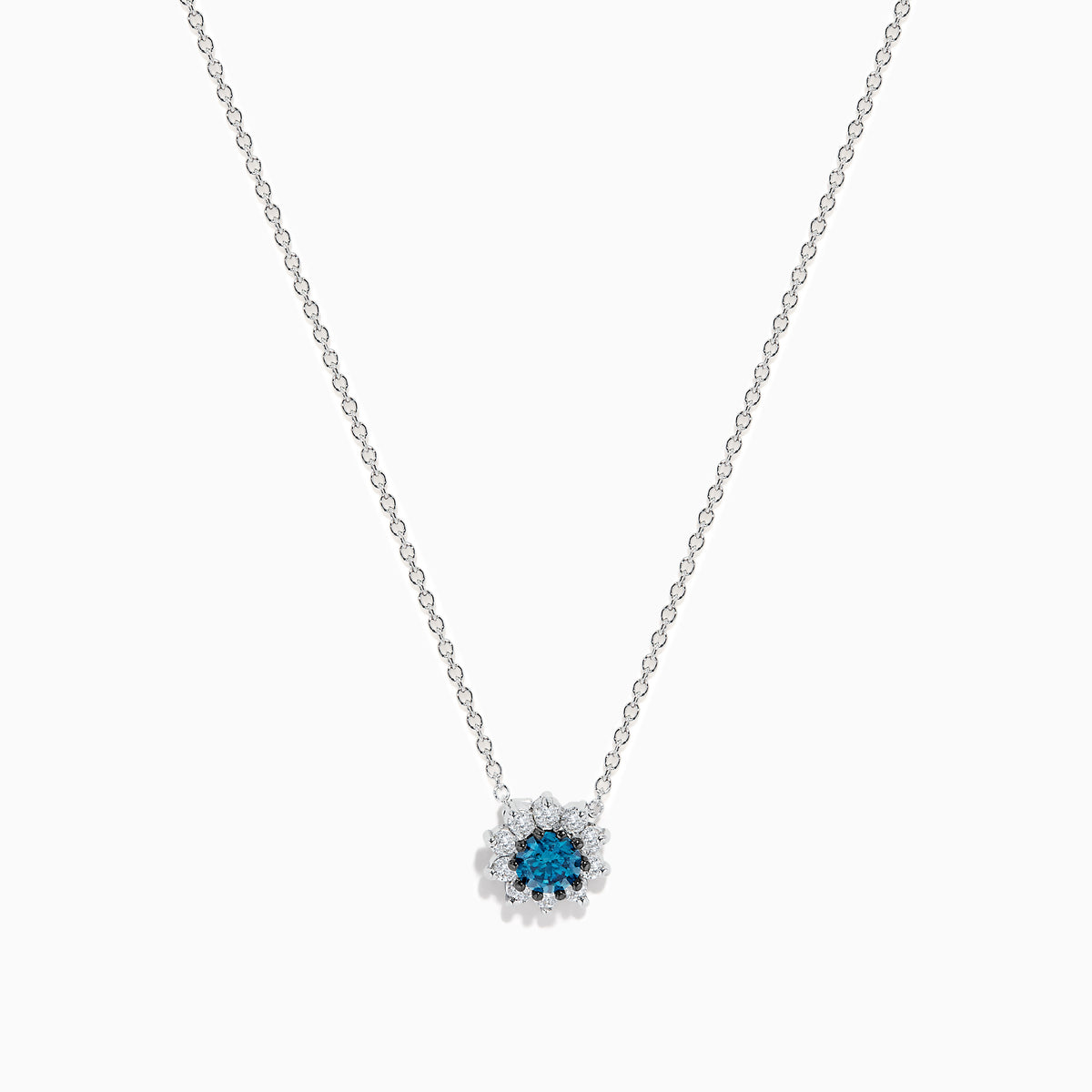 The Bella Bleu 14K White Gold Pendant showcases a round blue and white diamond centerpiece, accented by a halo of 0.60 TCW diamonds, elegantly presented on a white background.
