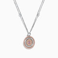 The 18K Two Tone Gold White and Pink Diamond Pendant necklace features a double-chain design with a round pendant of concentric circles, set with white and pink diamonds and topped by a single white gemstone.