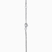 The 18K Two Tone Gold White and Pink Diamond Pendant necklace features a double-chain design with a round pendant of concentric circles, set with white and pink diamonds and topped by a single white gemstone.