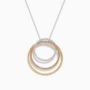 The 18K Gold Pink, Yellow and White Diamond Circles Pendant features three interlocking rings in tri-color gold with pink, yellow, and white diamonds on a silver chain against a white background.