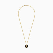 The Mens 14K Yellow Gold Black Diamond Lion Head Pendant features a detailed lion head on a black textured background, red eyes, and hangs from a shiny medium-thick chain for an impressive look.