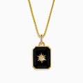 A 14K yellow gold agate and diamond pendant necklace with a rectangular black agate, gold starburst design, and a small central diamond, shown on a plain white background.