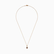 The 14K Rose Gold Brown and White Diamond Halo Pendant features an oval brown and white diamond surrounded by small clear stones in a decorative setting.