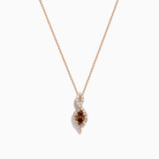 The 14K Rose Gold Brown and White Diamond Pendant features a marquise-shaped brown gemstone at its center, highlighted by a twisting design set with sparkling brown and white diamonds.