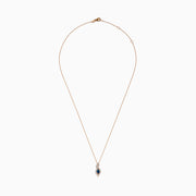 The 14K Rose Gold Blue and White Diamond Pendant features a deep blue oval gemstone with sparkling blue and white diamonds set in a twisting, teardrop-shaped design.