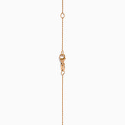 The 14K Rose Gold Blue and White Diamond Pendant features a deep blue oval gemstone with sparkling blue and white diamonds set in a twisting, teardrop-shaped design.