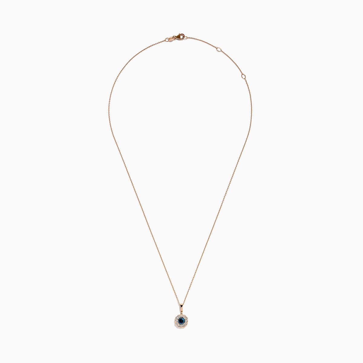 The Bella Bleu 14K Rose Gold Blue and White Diamond Pendant features a round dark blue gemstone center, encircled by sparkling white diamonds, all on a rose gold chain and shown against a white background.