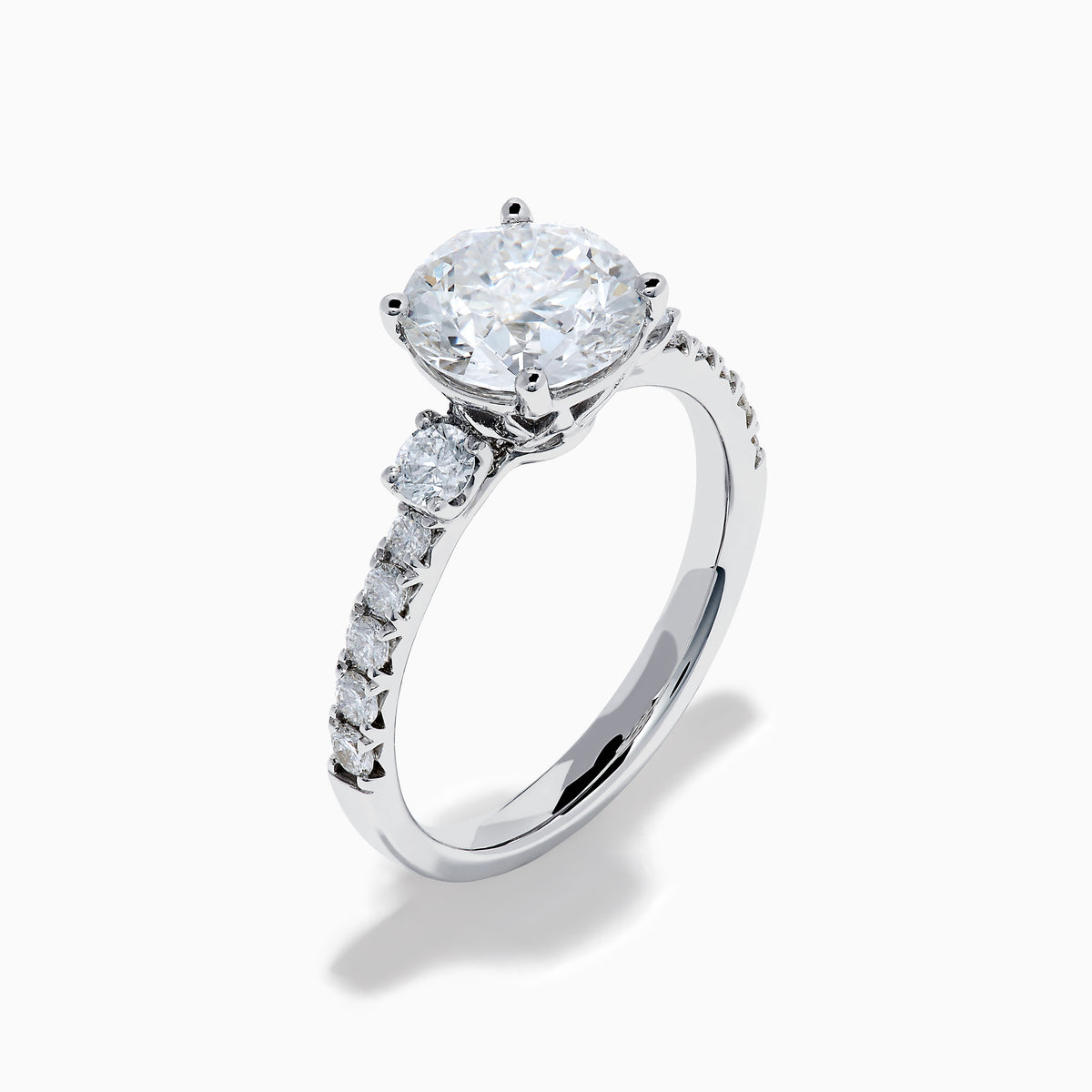 The Star Lab Grown Diamond Ring in 18K White Gold showcases a large round-cut lab diamond center with smaller diamonds along the band, beautifully displayed on a white background.