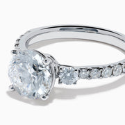 The Star Lab Grown Diamond Ring in 18K White Gold showcases a large round-cut lab diamond center with smaller diamonds along the band, beautifully displayed on a white background.