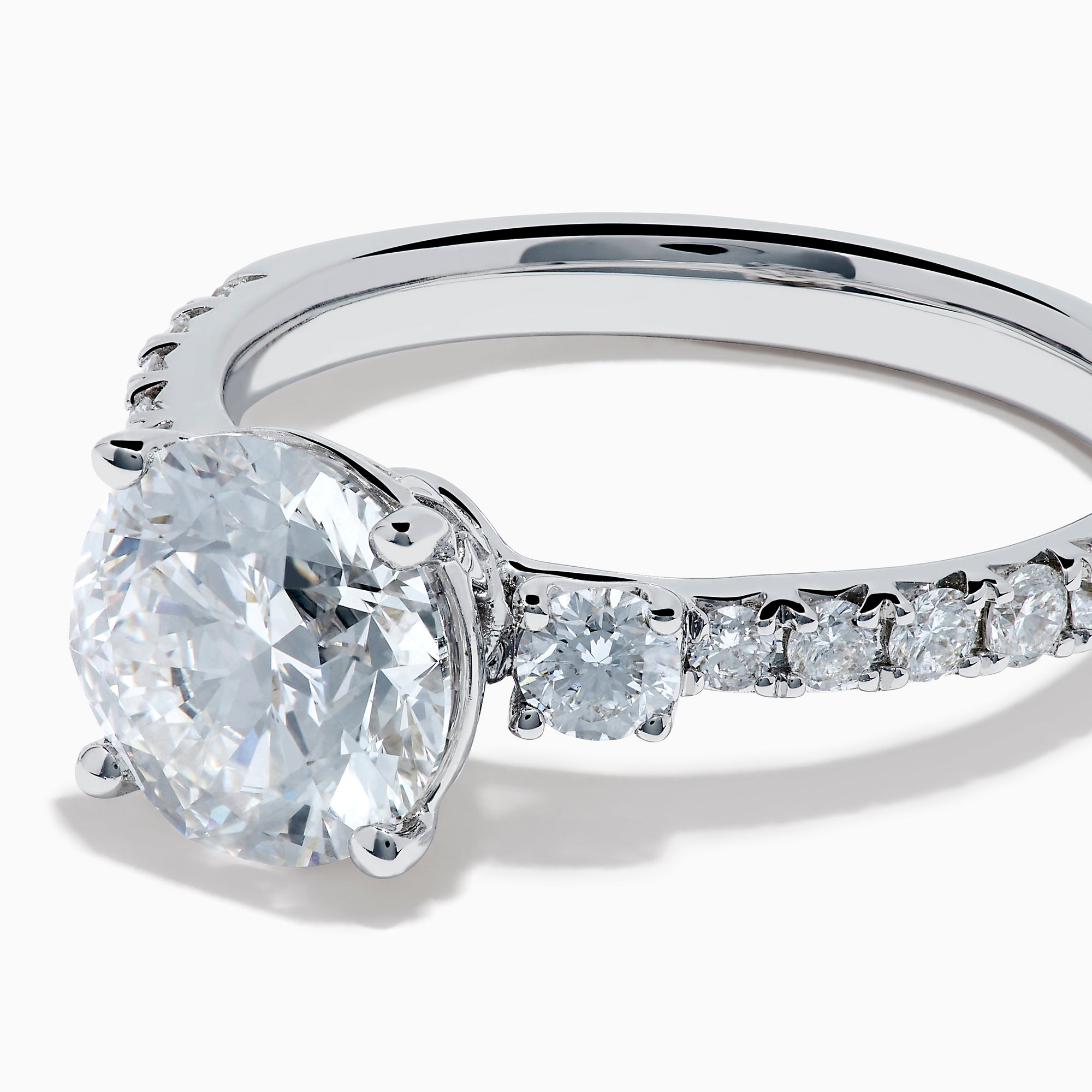 The Star Lab Grown Diamond Ring in 18K White Gold showcases a large round-cut lab diamond center with smaller diamonds along the band, beautifully displayed on a white background.
