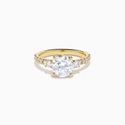 The Star Lab Grown Diamond Ring in 18K yellow gold features a large round center stone with smaller diamonds along the band, shown against a white background.