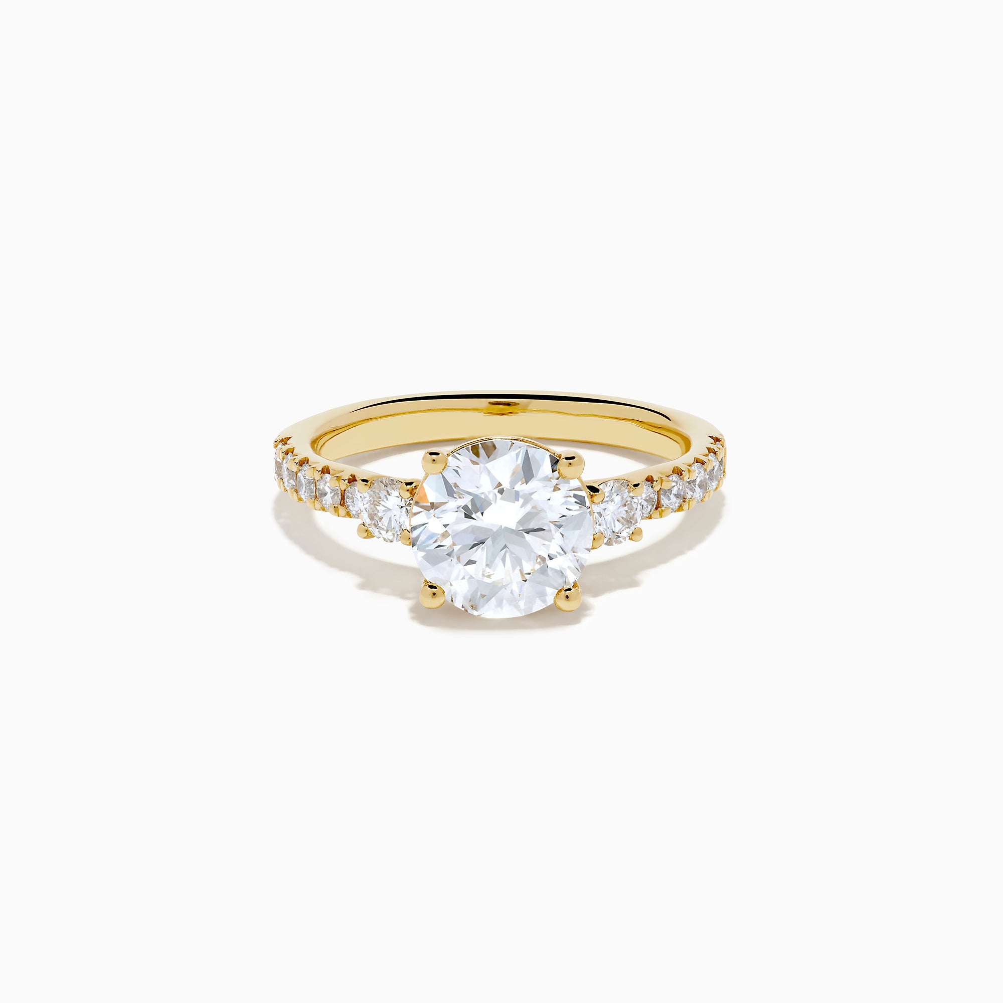 The Star Lab Grown Diamond Ring in 18K yellow gold features a large round center stone with smaller diamonds along the band, shown against a white background.
