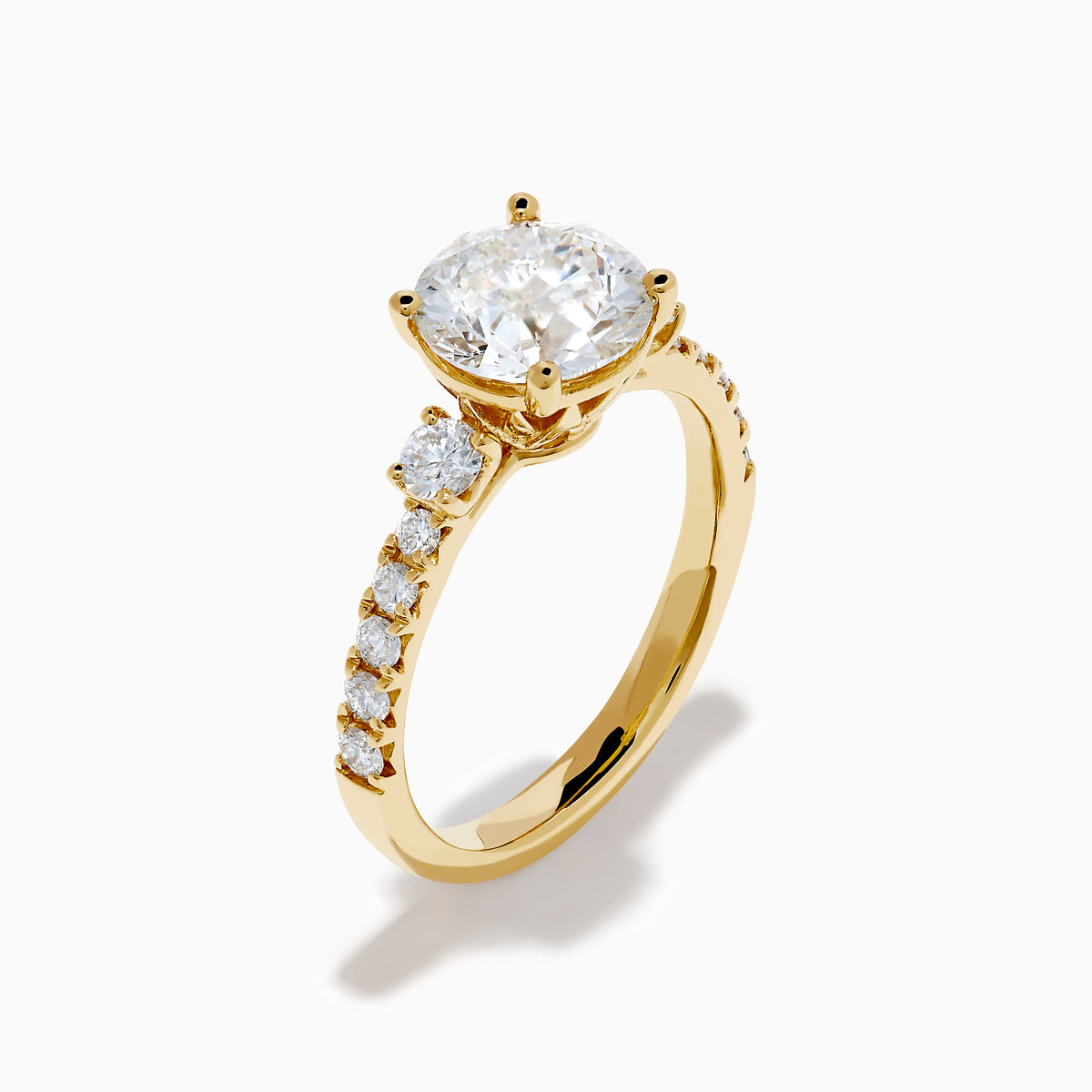 The Star Lab Grown Diamond Ring in 18K yellow gold features a large round center stone with smaller diamonds along the band, shown against a white background.