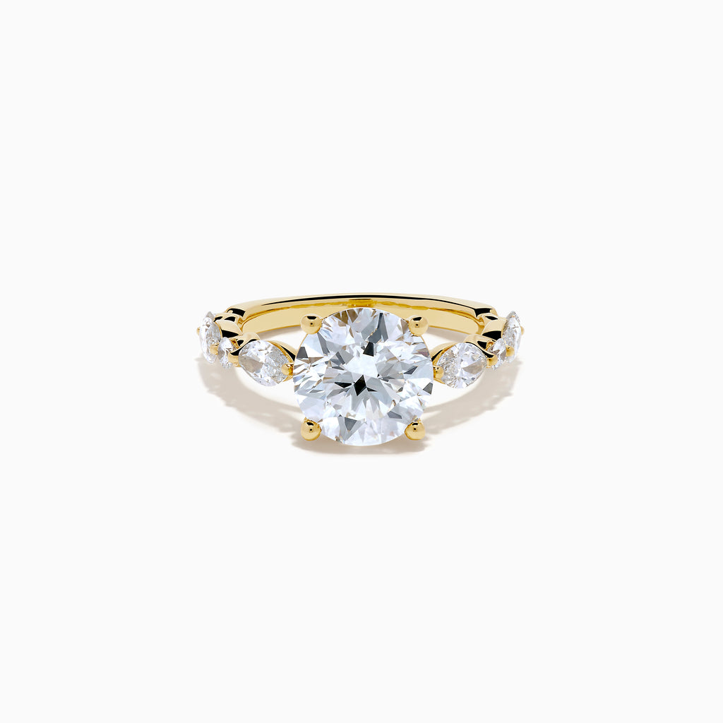 The Star Lab Grown Diamond Ring in 18K Yellow Gold features a large round lab diamond center, accented by three smaller diamonds on each side, all set against a white background.