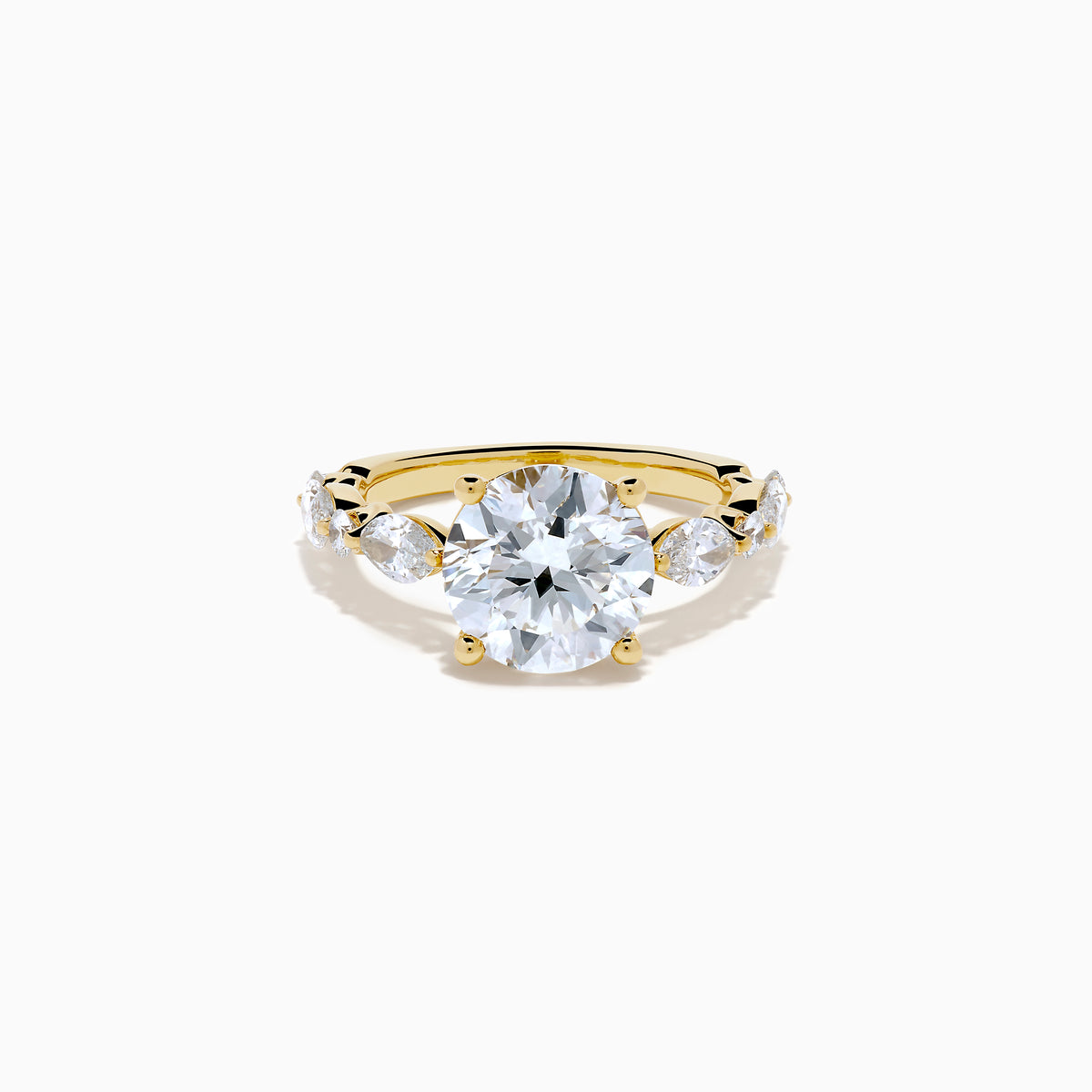 The Star Lab Grown Diamond Ring in 18K Yellow Gold features a large round lab diamond center, accented by three smaller diamonds on each side, all set against a white background.