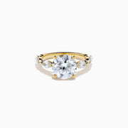 The Star Lab Grown Diamond Ring in 18K Yellow Gold features a large round lab diamond center, accented by three smaller diamonds on each side, all set against a white background.