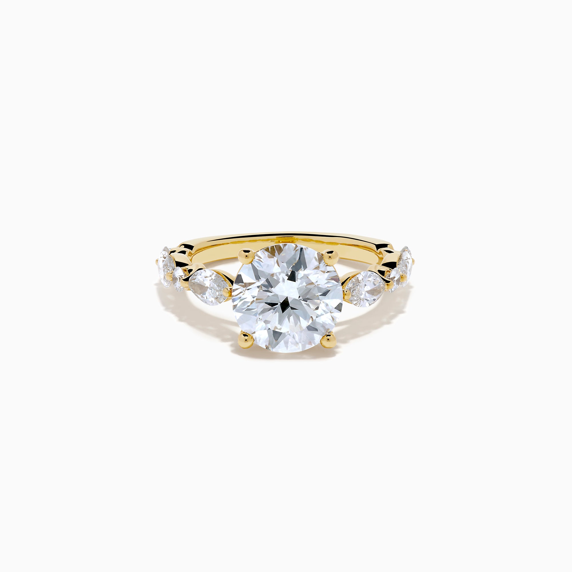 The Star Lab Grown Diamond Ring in 18K Yellow Gold features a large round lab diamond center, accented by three smaller diamonds on each side, all set against a white background.