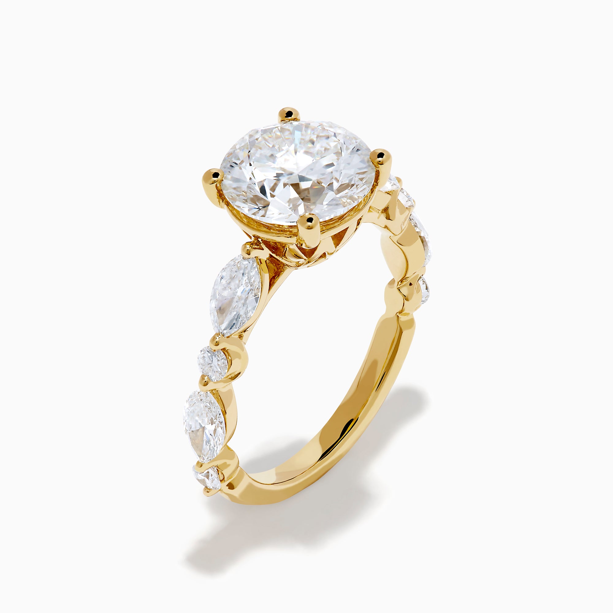 The Star Lab Grown Diamond Ring in 18K Yellow Gold features a large round lab diamond center, accented by three smaller diamonds on each side, all set against a white background.