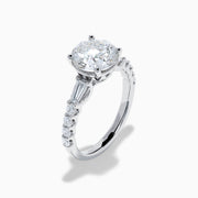 The Star Lab Grown Diamond Ring in 18K White Gold showcases a large oval-cut center stone with baguette and round accents along the band, elegantly presented on a white background.