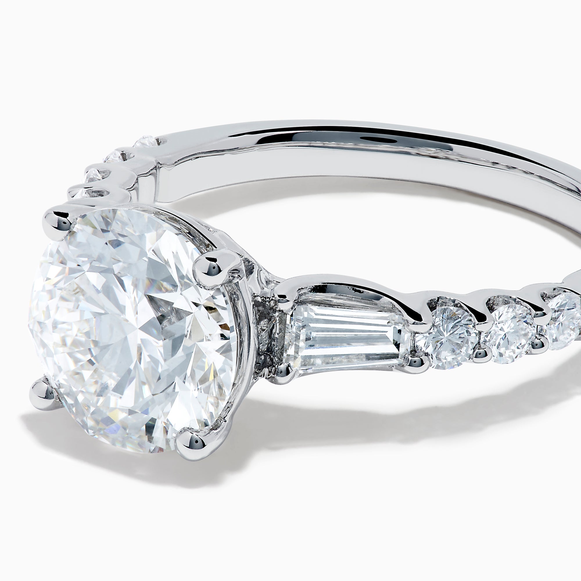The Star Lab Grown Diamond Ring in 18K White Gold showcases a large oval-cut center stone with baguette and round accents along the band, elegantly presented on a white background.