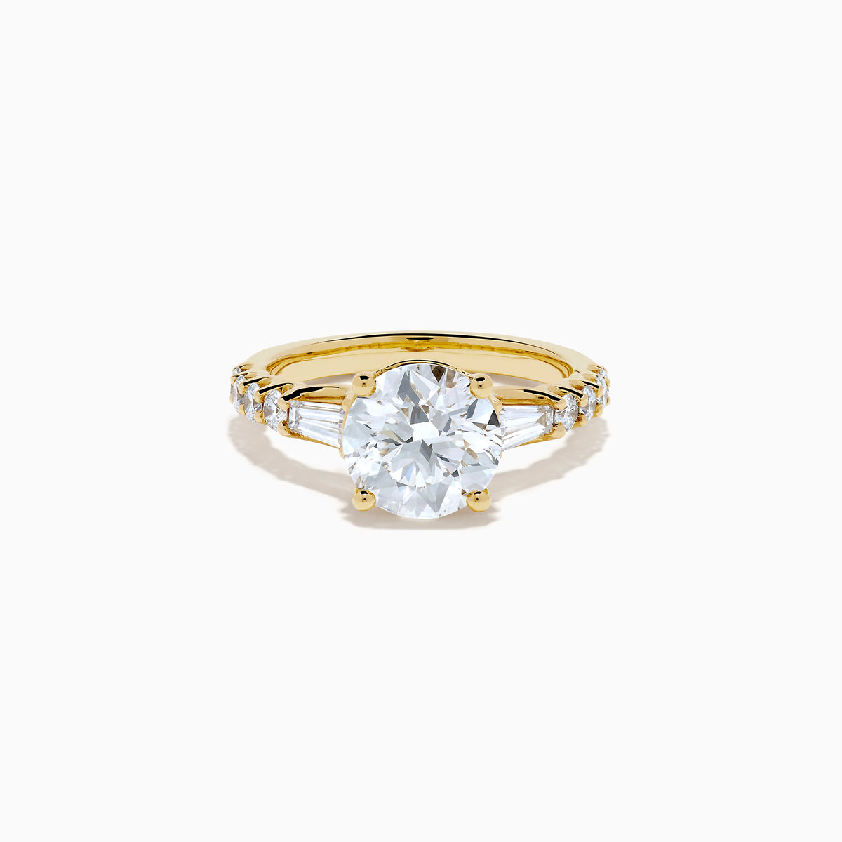 The Star Lab Grown Diamond Ring in 18K Yellow Gold showcases a large oval-cut lab diamond center stone with smaller rectangular accents along the band, elegantly displayed on a plain white background.