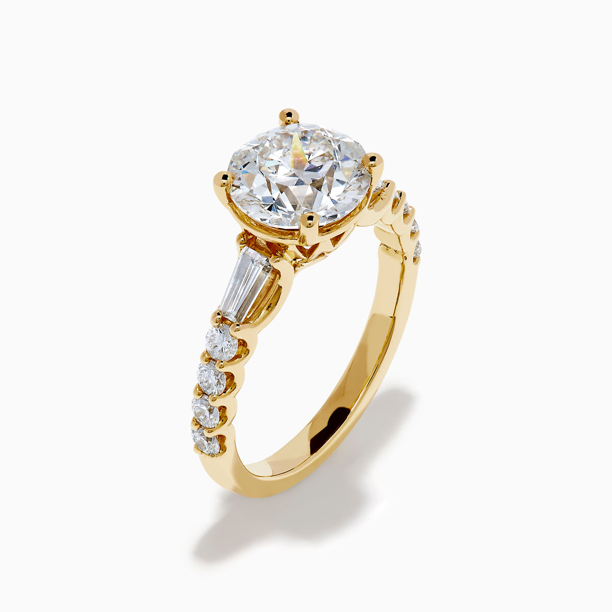 The Star Lab Grown Diamond Ring in 18K Yellow Gold showcases a large oval-cut lab diamond center stone with smaller rectangular accents along the band, elegantly displayed on a plain white background.