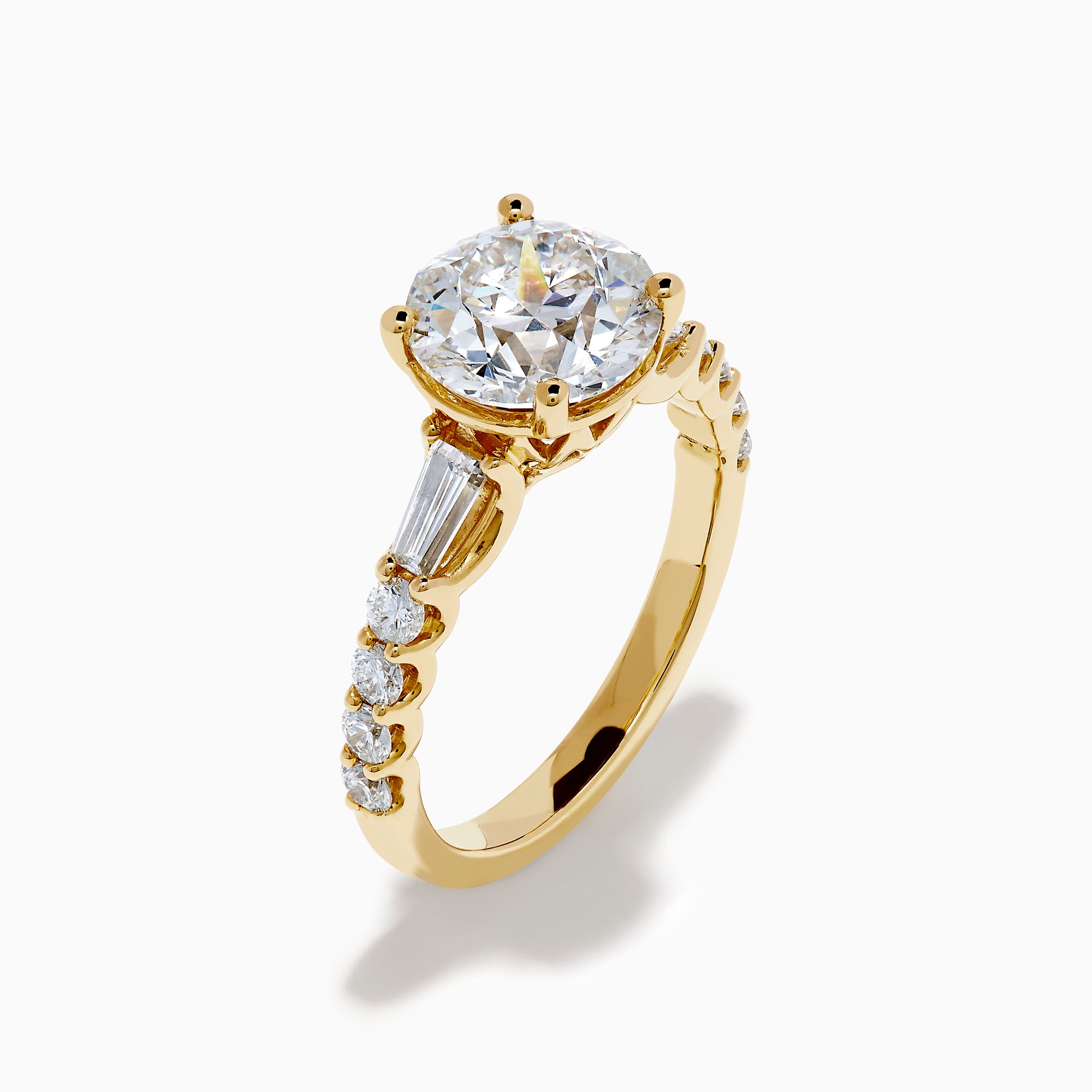 The Star Lab Grown Diamond Ring in 18K Yellow Gold showcases a large oval-cut lab diamond center stone with smaller rectangular accents along the band, elegantly displayed on a plain white background.